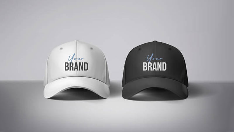 White and black custom baseball caps showing Your Brand logo for promotional use