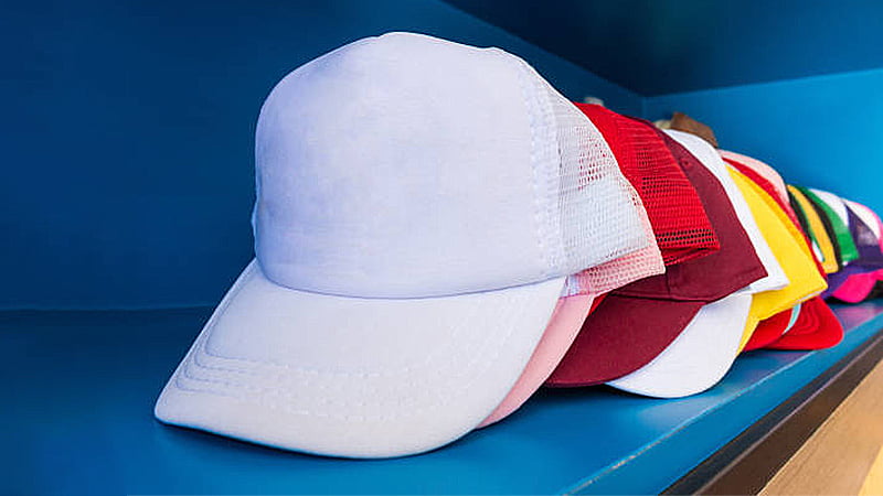 Colorful blank mesh trucker caps lined up on a shelf, highlighting color choices for bulk custom hat orders