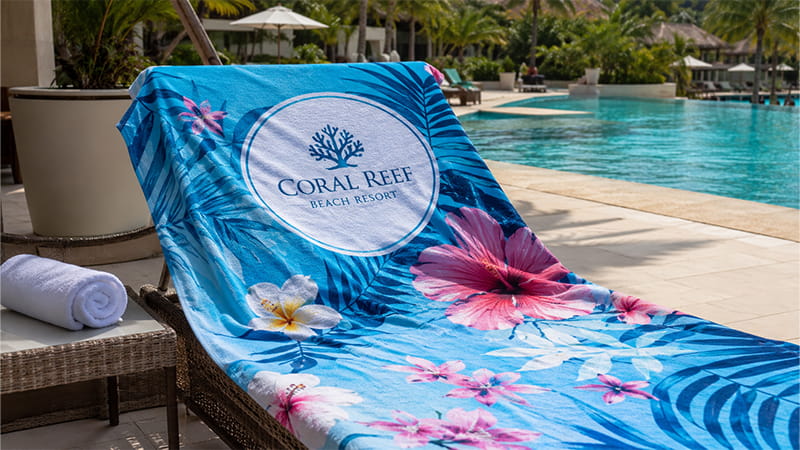 Printed beach towel displayed on a poolside lounger