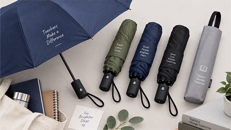 Compact and full-size umbrellas prepared as practical teacher appreciation gifts for outdoor school duties.